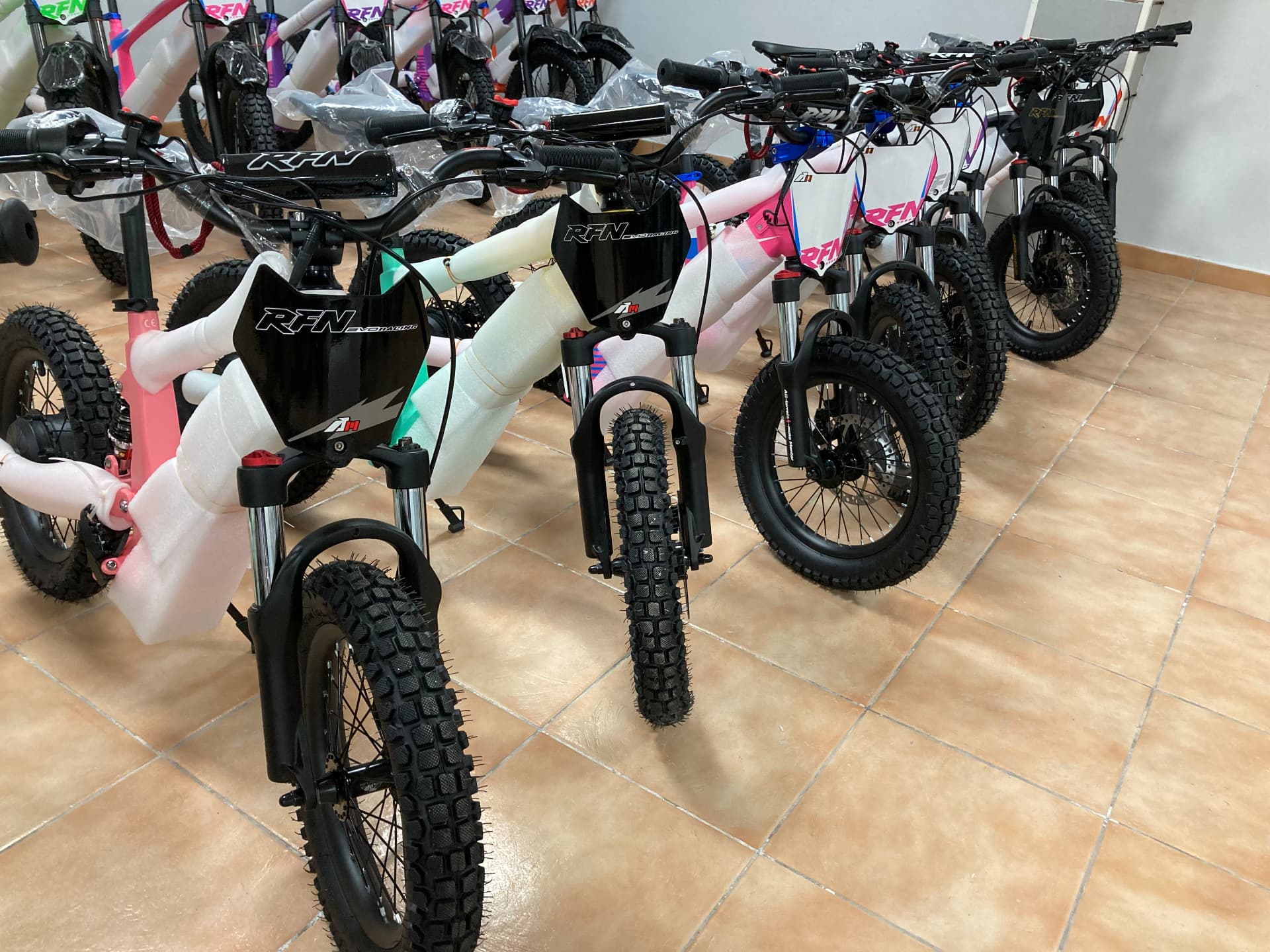 Bicicletas eléctricas infantiles RFN EVO Racing en rosa, verde menta, blanco y negro con protecciones de embalaje