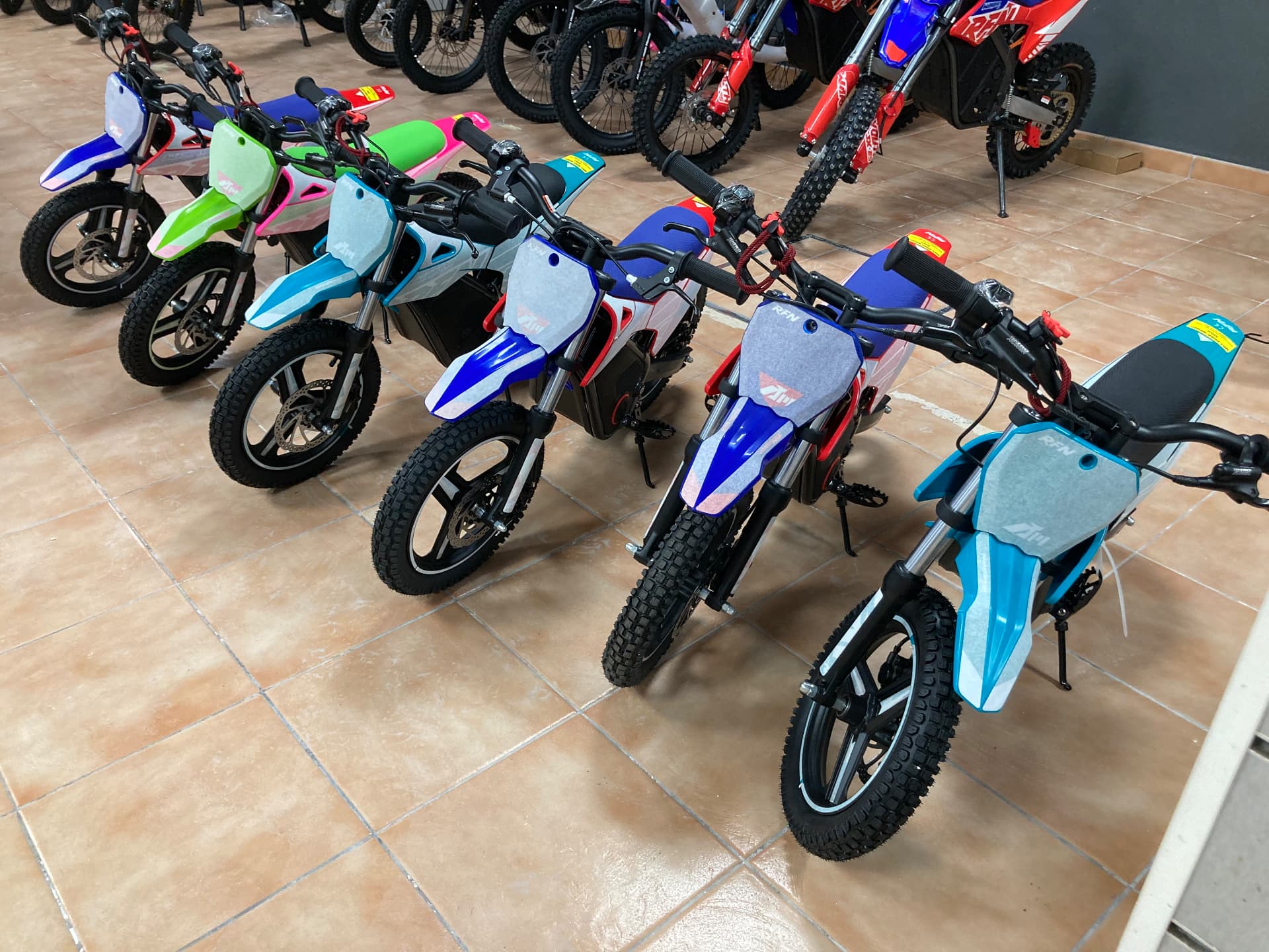 Minicross eléctricas de colores alineadas en la tienda