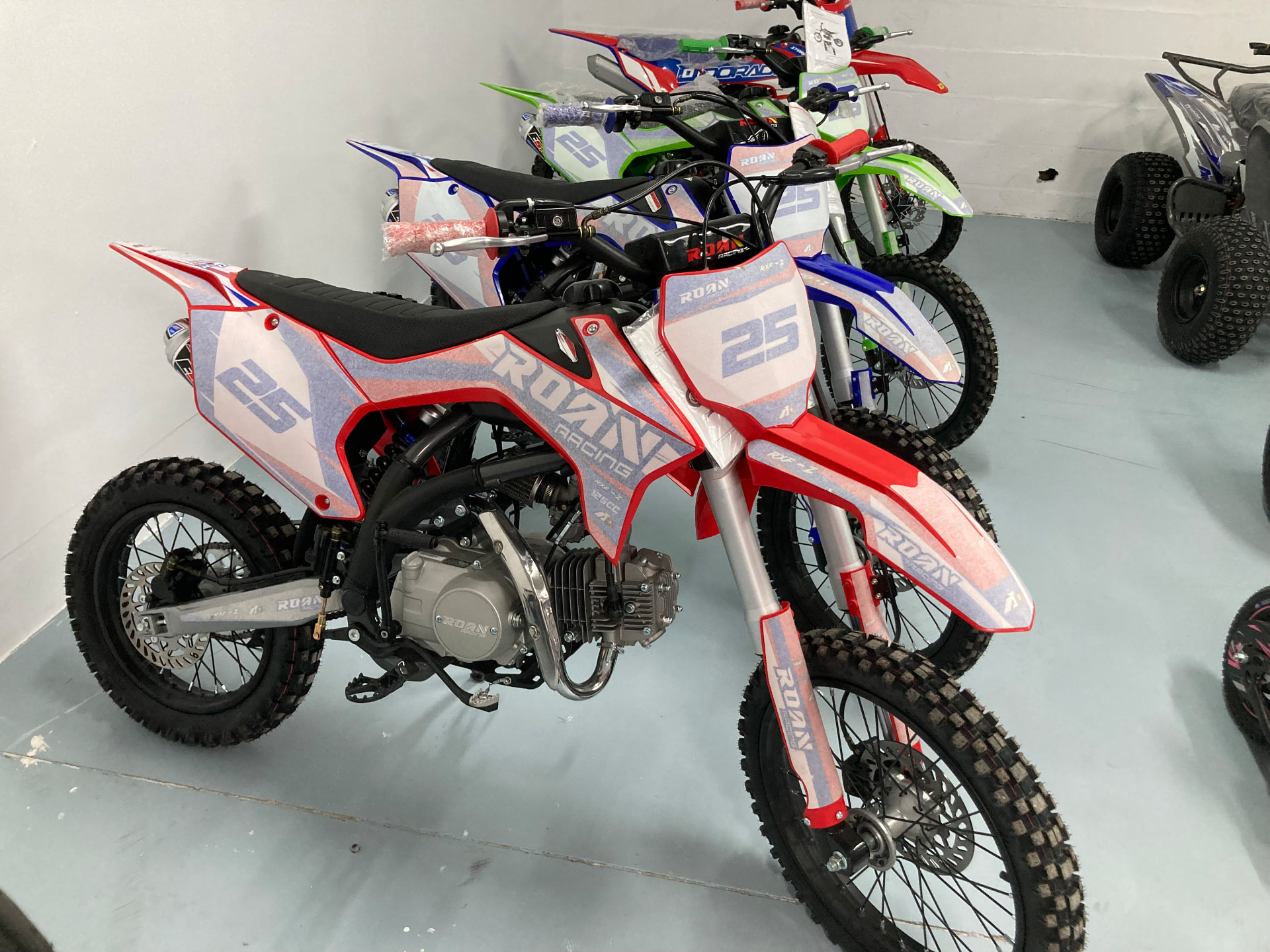 Fila de motos de cross ROAN con el dorsal 25 en la exposición