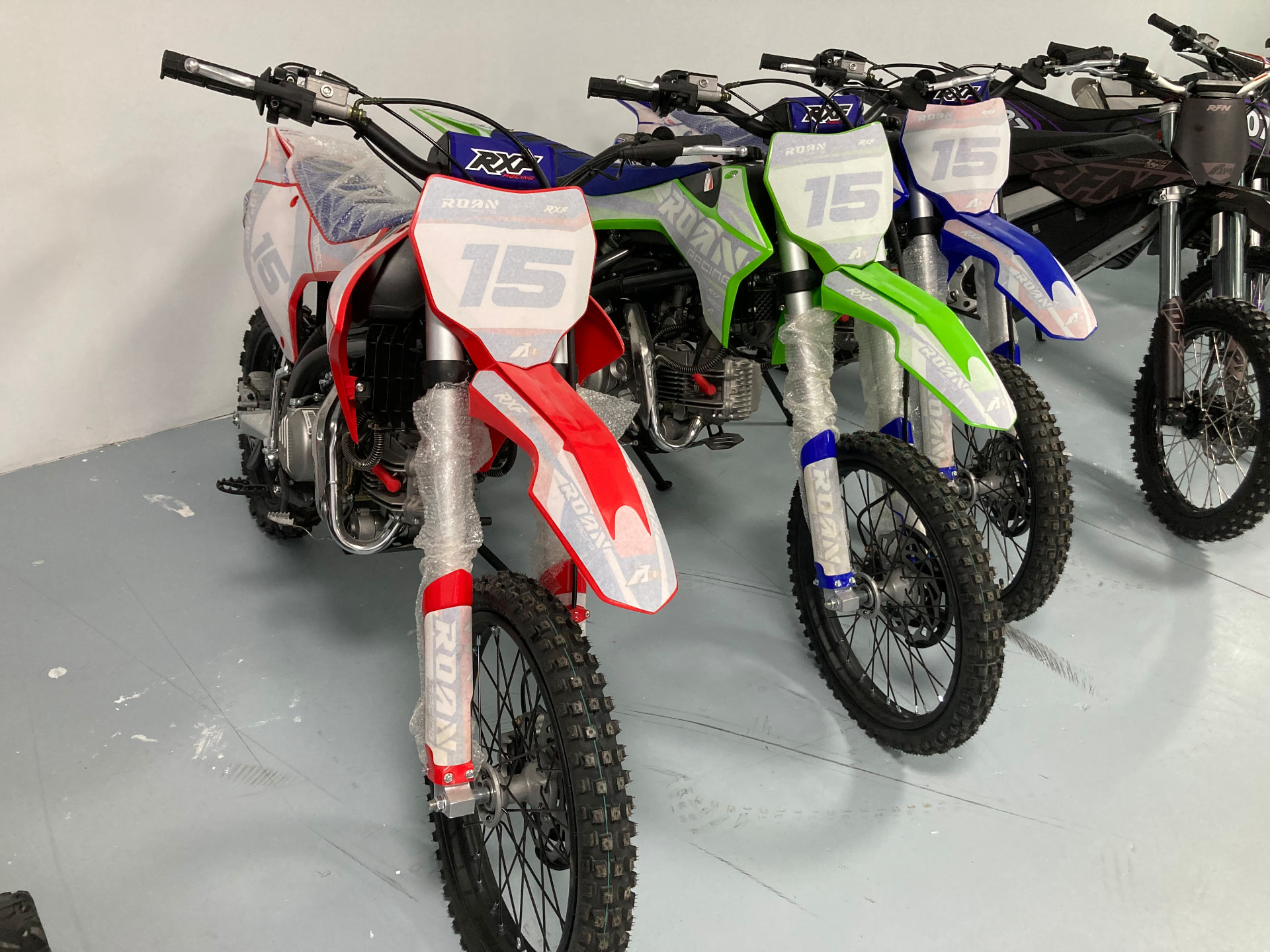 Motos de cross ROAN nuevas con el dorsal 15 en rojo, verde y azul